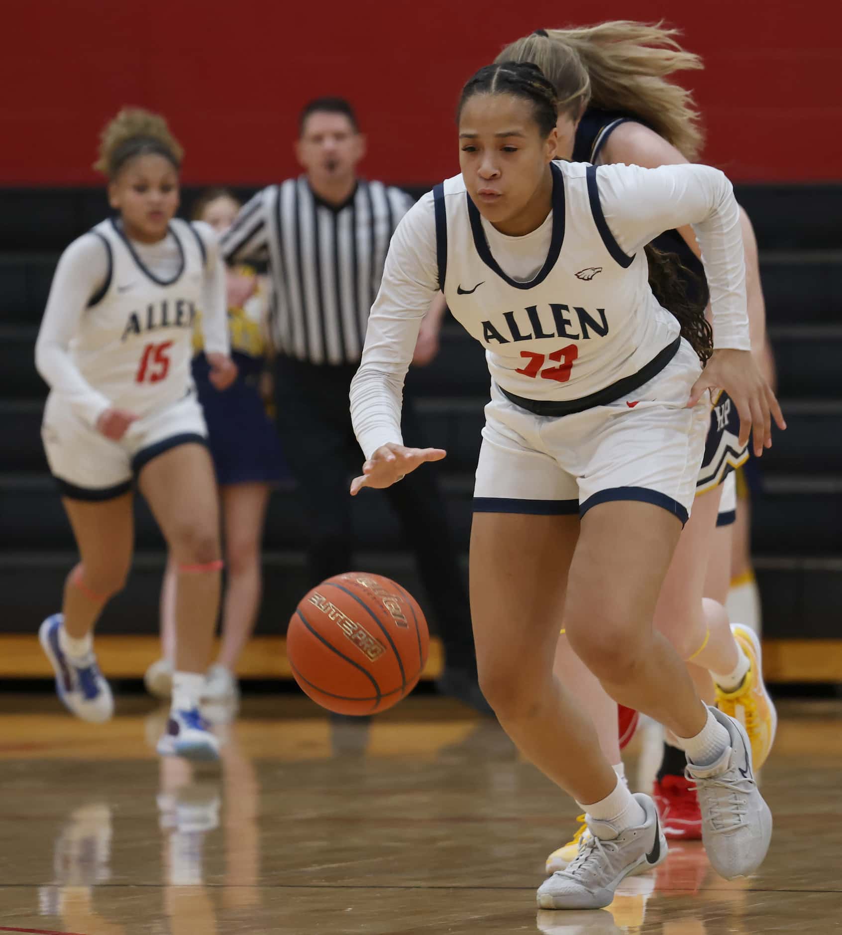 Allen's Aryn Roberts (23) dribbles past mid court as she is pursued by a Highland Park...