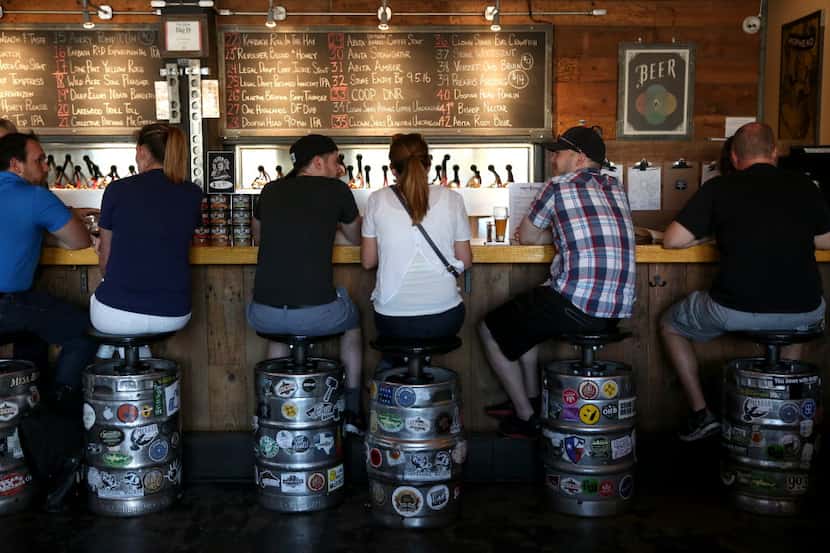 Patrons enjoy a beer at Craft and Growler in Dallas.