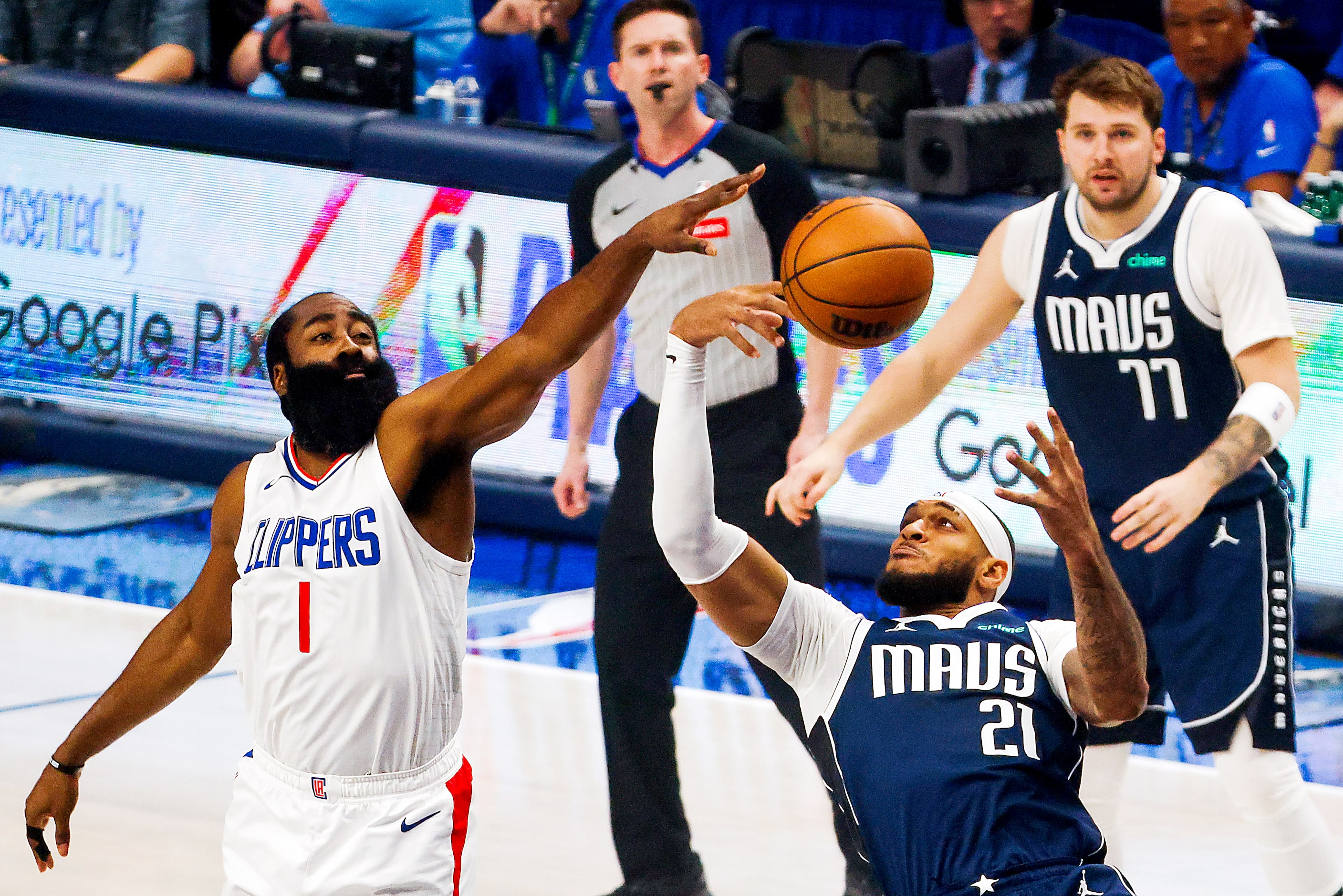 LA Clippers guard James Harden (1) and Dallas Mavericks center Daniel Gafford (21) reaches...