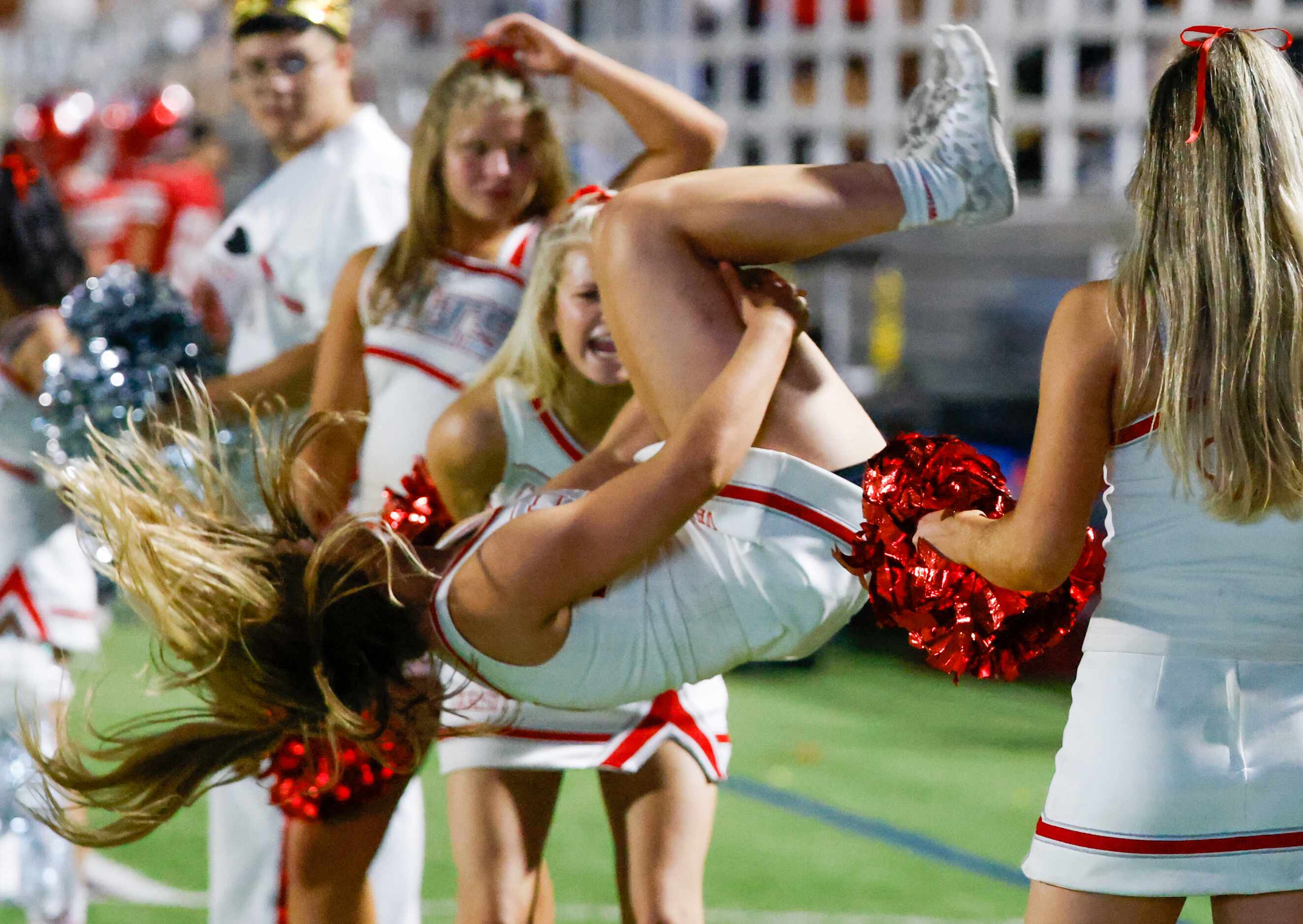 Woodrow Wilson cheerleaders flip as they pump up the crowd during the second half of a game...
