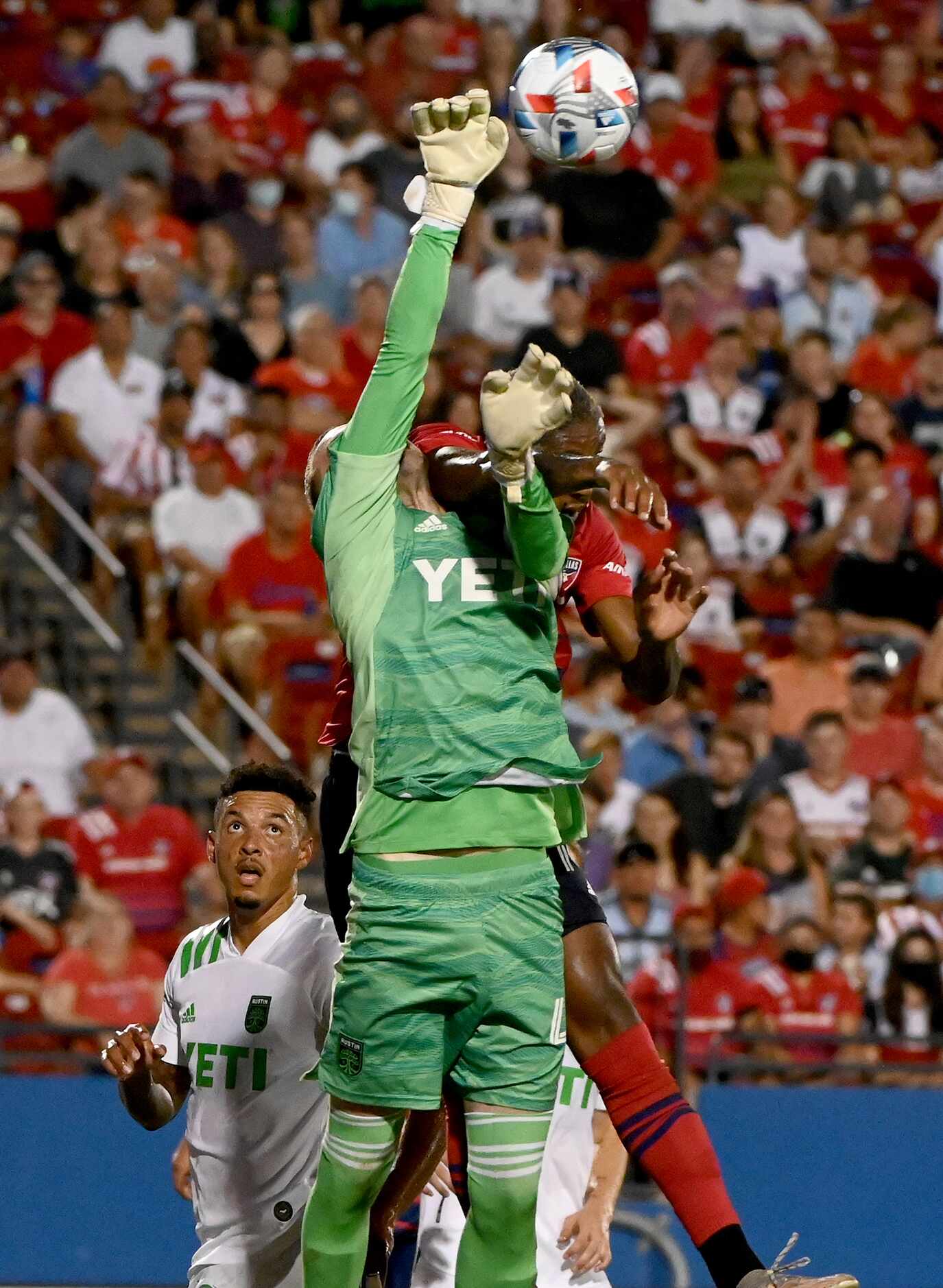 Austin FC goalkeeper Brad Stuver (41) punches the ball away from FC Dallas defender Nkosi...