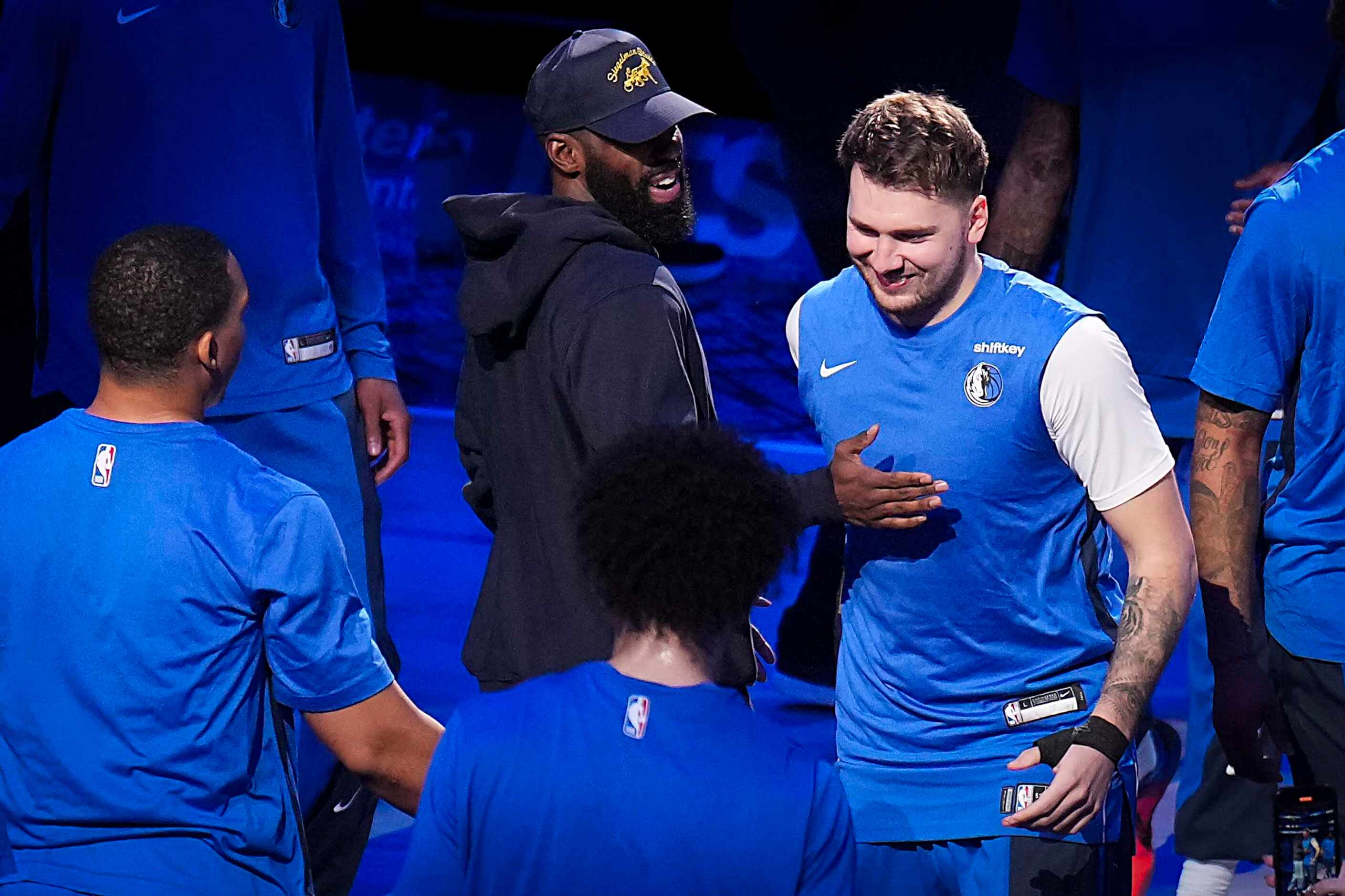 Dallas Mavericks guard Luka Doncic gets a pat on the chest from guard Kyrie Irving as he...