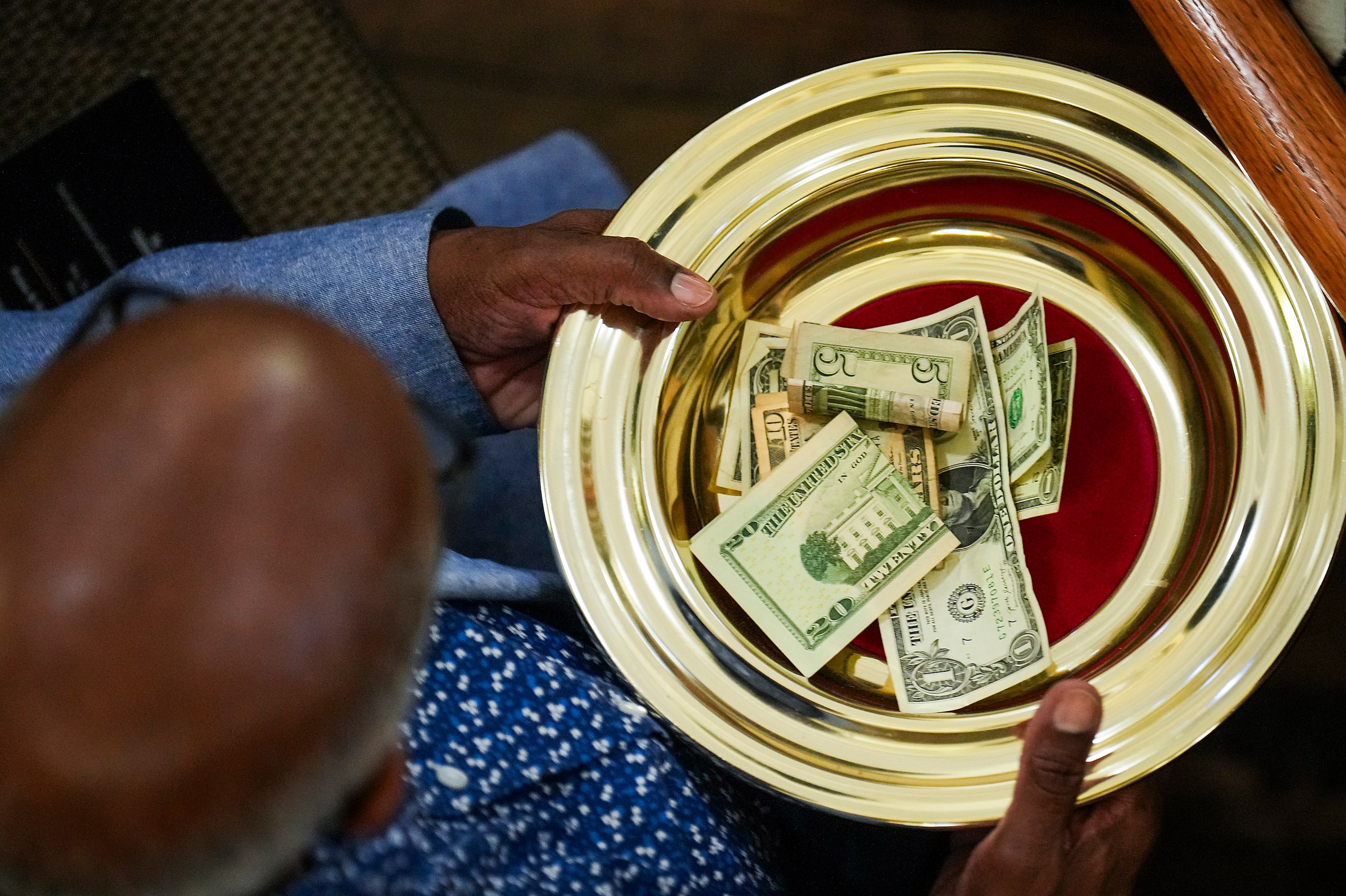 Offering plates are passed during a special worship service celebrating the 150th...