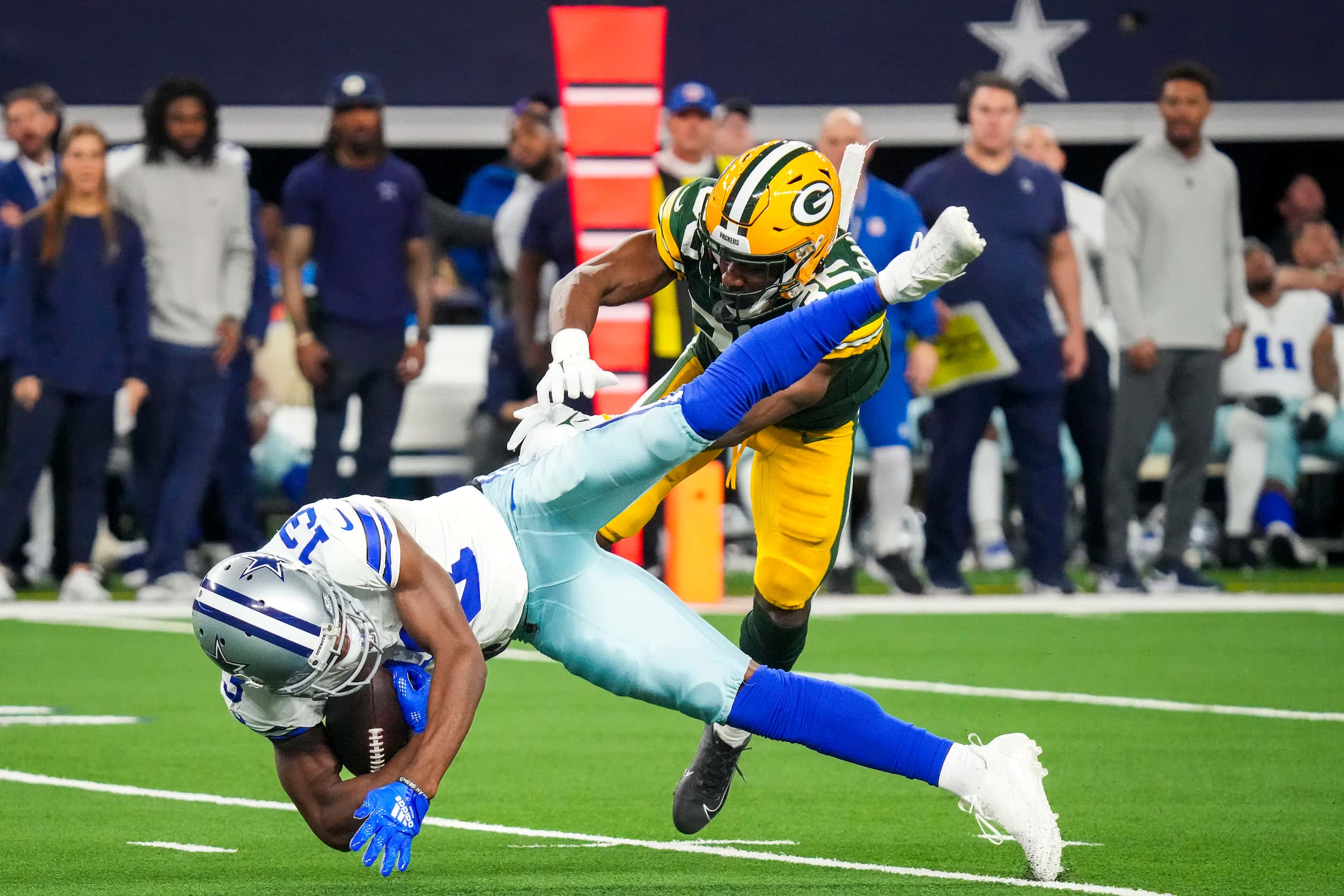 Dallas Cowboys wide receiver Michael Gallup (13) is upended by Green Bay Packers cornerback...