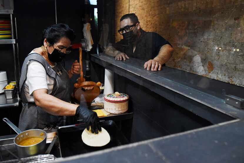 Chef Gino Rojas, far-right, watches his mom, Juanita Rojas, make fresh tortillas inside La...
