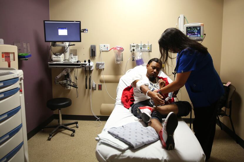 Stephanie Warnock, a registered nurse, helps discharge patient Ricardo Sotelo in the...