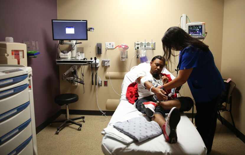 Stephanie Warnock, a registered nurse, helps discharge patient Ricardo Sotelo in the...