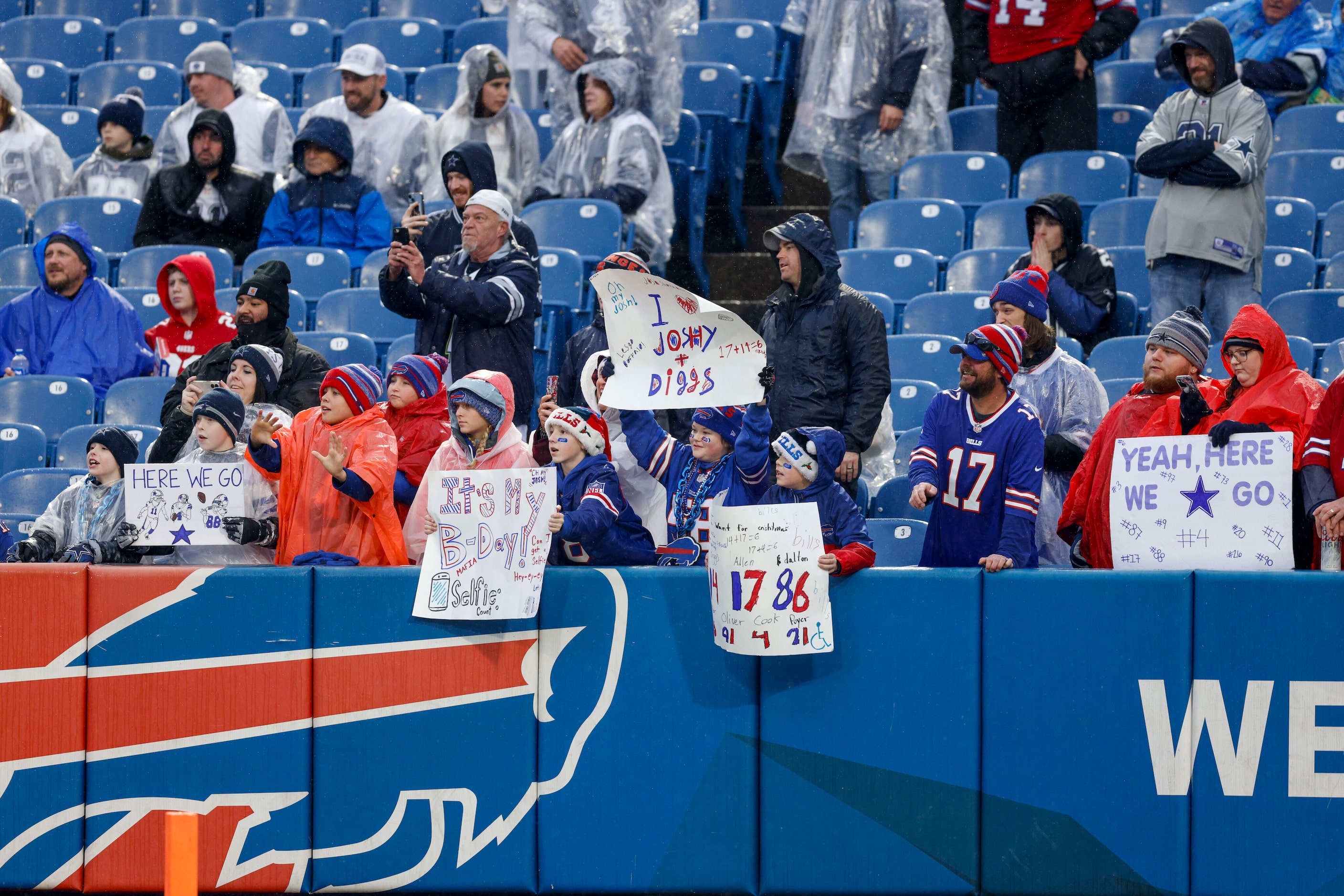 Fans hold signs before an NFL game between the Dallas Cowboys and the Buffalo Bills, Sunday,...