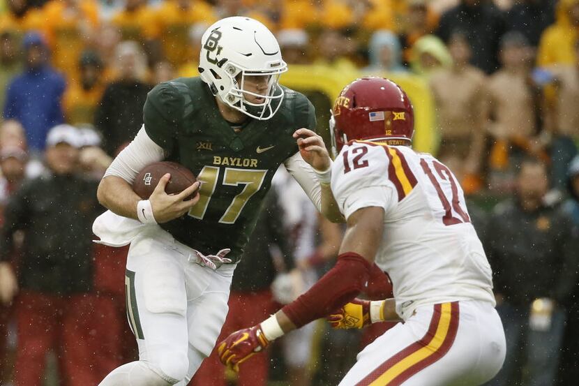 Baylor quarterback Seth Russell (17) looks for running room as Iowa State linebacker Jarnor...