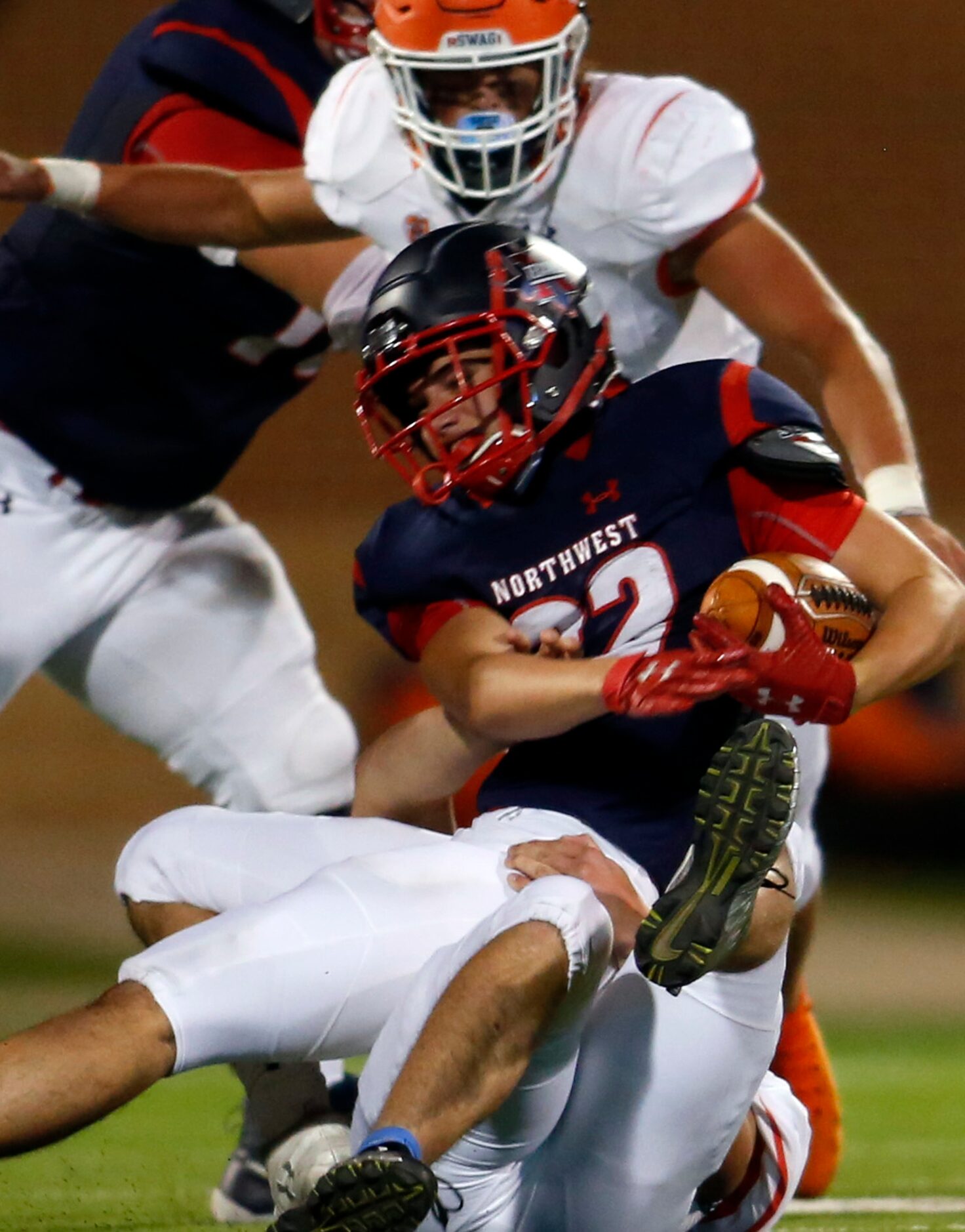 Northwest running back Kyle Cummings (22) feels the crunch of the McKinney North defense...