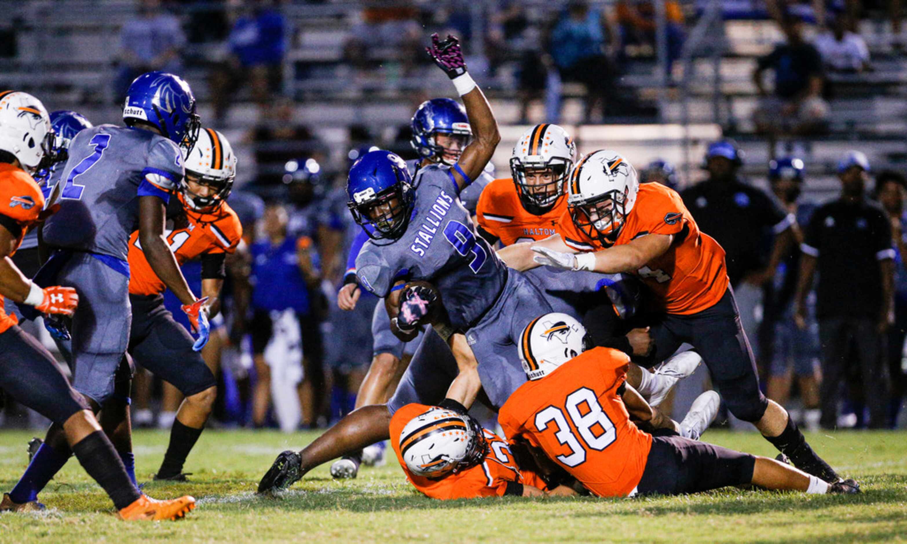 TXHSFB North Mesquite senior Samuel Inyang (9) is tackled by Haltom City defenders on a...