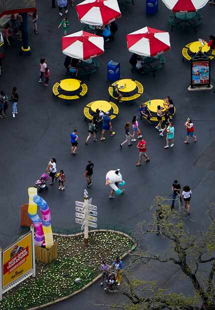 Park visitors walk near a food concession at Six Flags Over Texas on Thursday, March 12,...