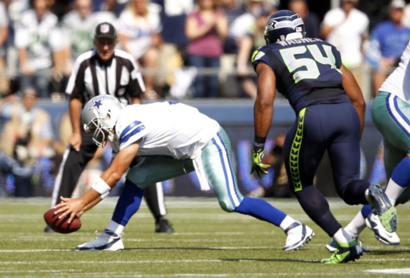 Dallas Cowboys quarterback Tony Romo (9) gathers the ball after a botched snap as Seattle...