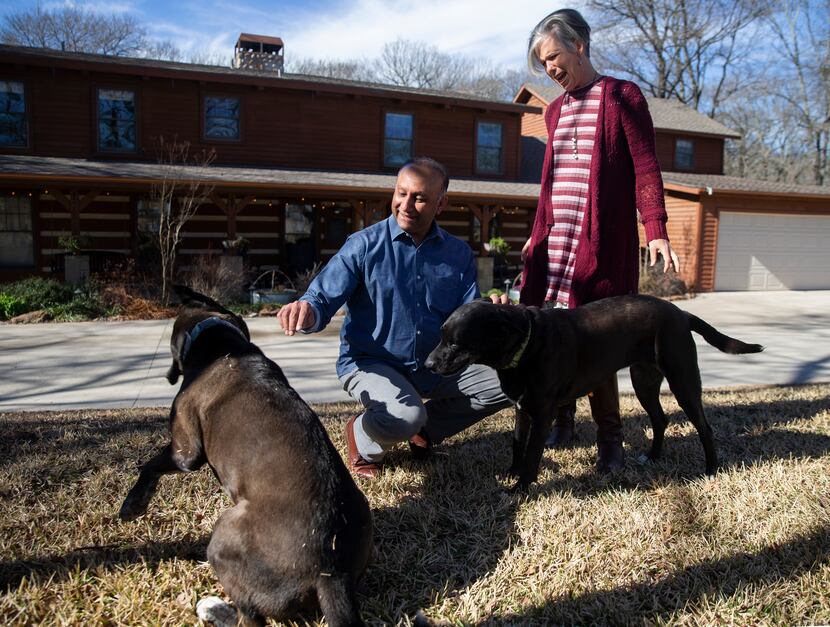 Ali Master and his wife, Judy, play with their dogs at their home in Rockwall. 