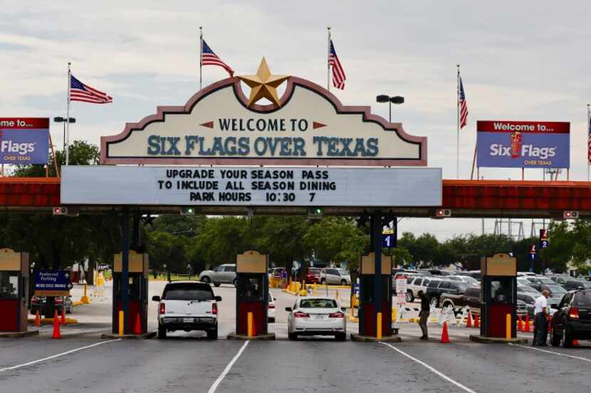 U.S Flags fly on the "Welcome to Six Flags Over Texas" sign on Friday afternoon, August 18,...