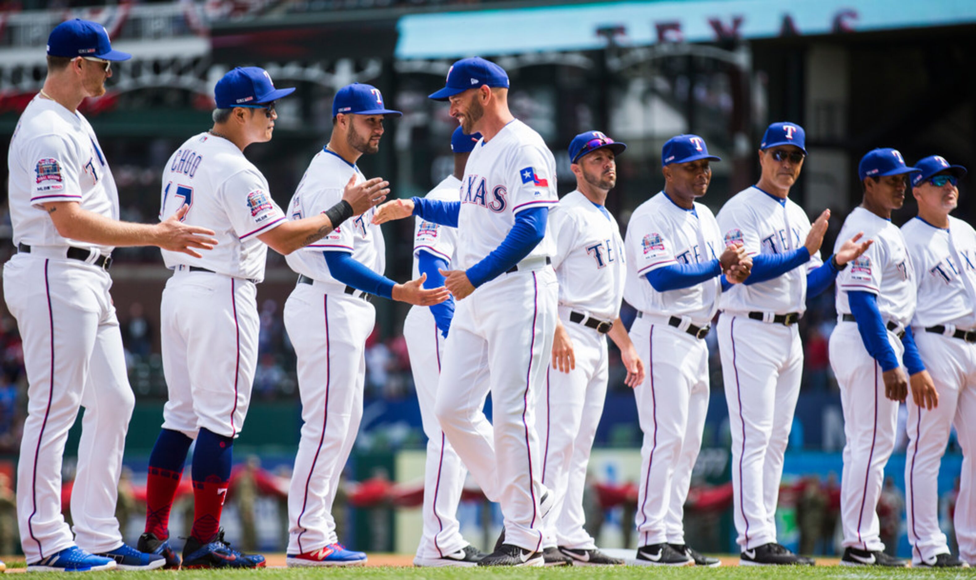 Texas Rangers manager Chris Woodward (8) greets players as he is introduced before an...