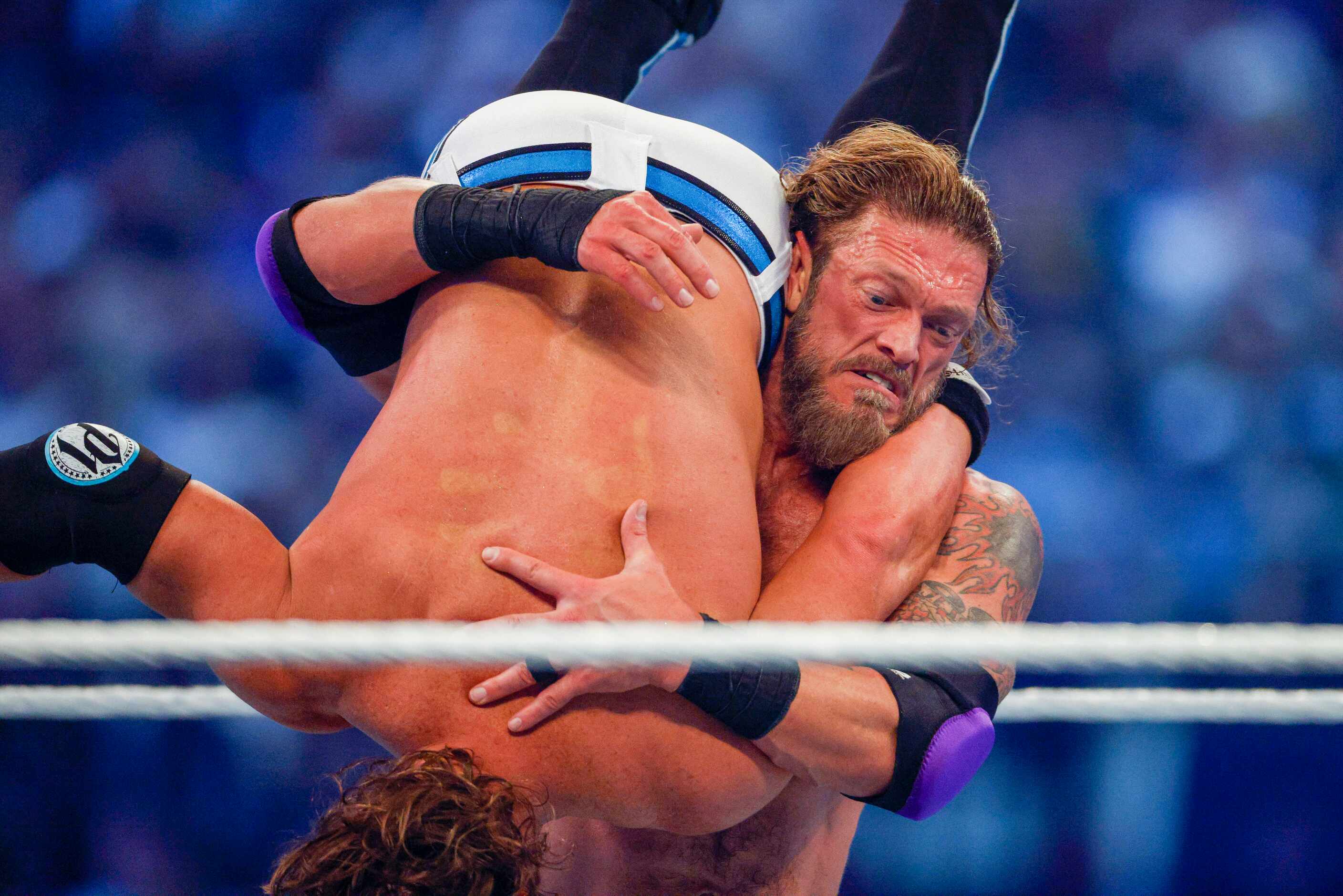 Edge (right) carries AJ Styles during a match at WrestleMania Sunday at AT&T Stadium in...