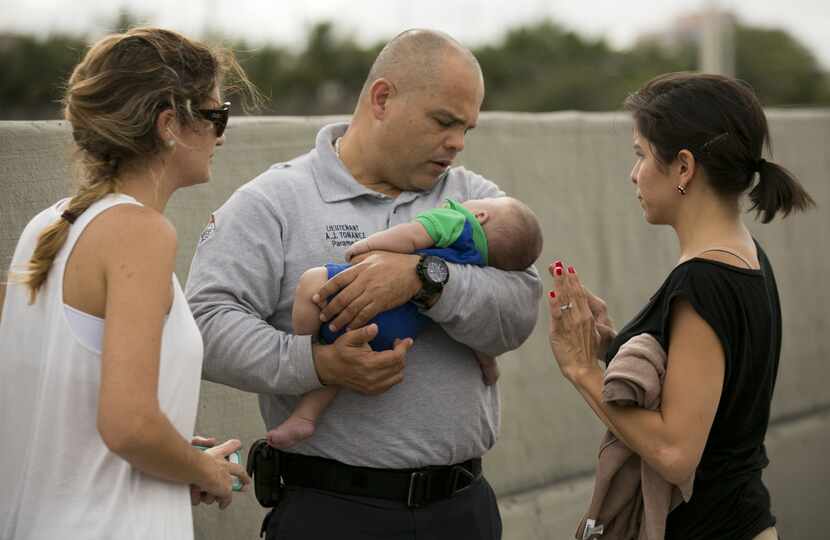 Miami-Dade Fire paramedic lieutenant Alvaro Tonanez helps rescue 5-month-old Sebastian de la...