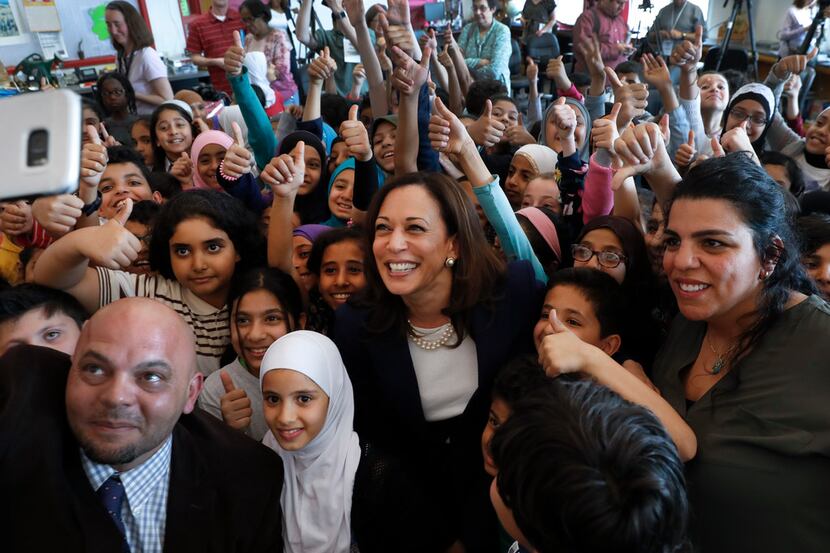 Democratic presidential candidate Sen. Kamala Harris, D-Calif., (center) poses with students...