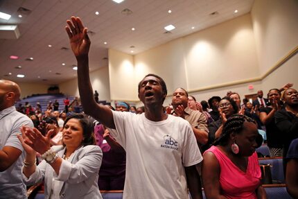 Members of the Living Faith Christian Center congregation sing a hymn at a prayer vigil for...