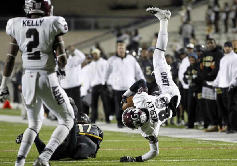 Wylie wide receiver Alex Wesley (88) is upended by South Oak Cliff defensive back Takadrae...