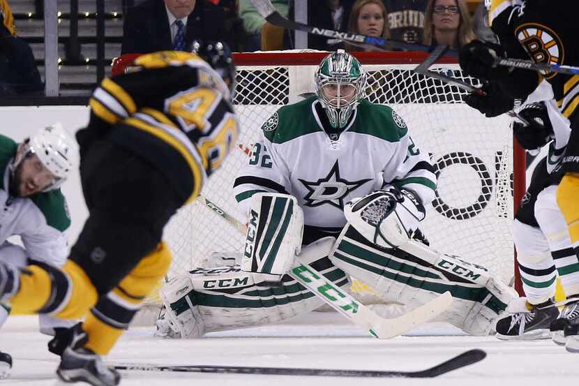 Boston Bruins' David Krejci, foreground, takes a shot on Dallas Stars' Kari Lehtonen (32)...