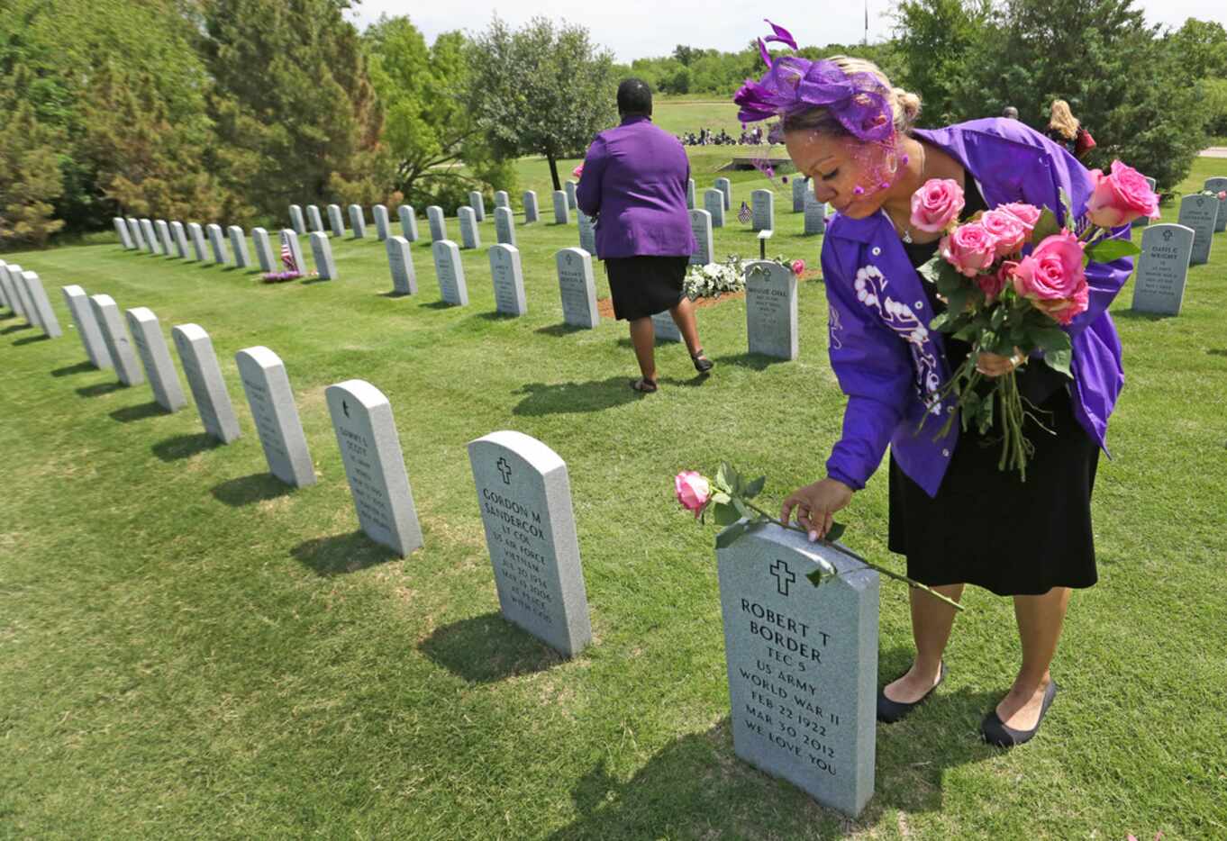 Anjelie Bargino (right) and Katrina Clark distributed flowers throughout the cemetery after...