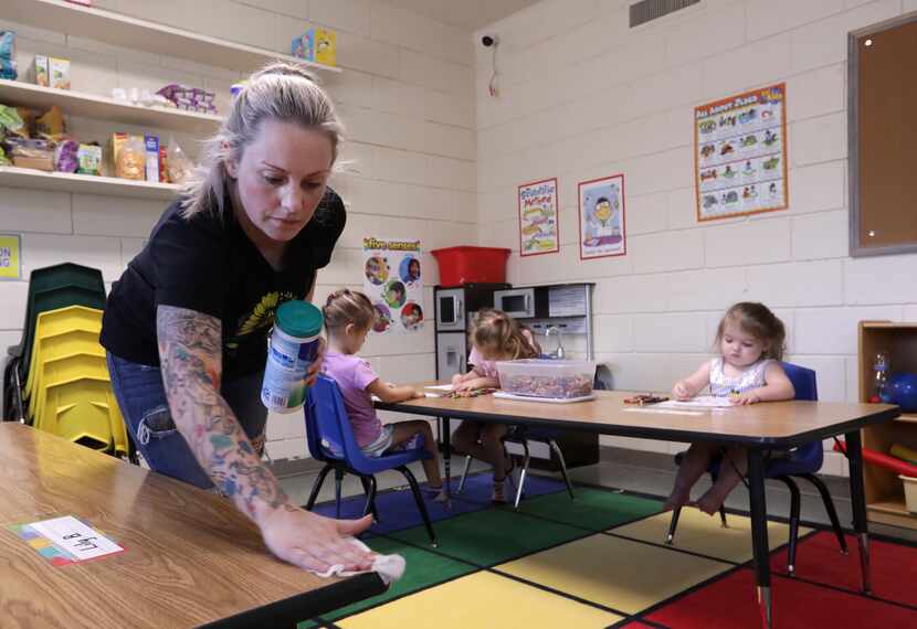 Ashley Boccanfuso cleans a table with sanitizing wipes at Young Disciples Discovery Center...