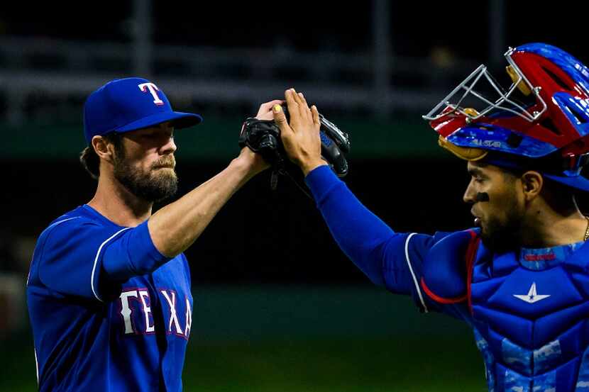 Texas Rangers starting pitcher Cole Hamels gets a hand from catcher Robinson Chirinos after...