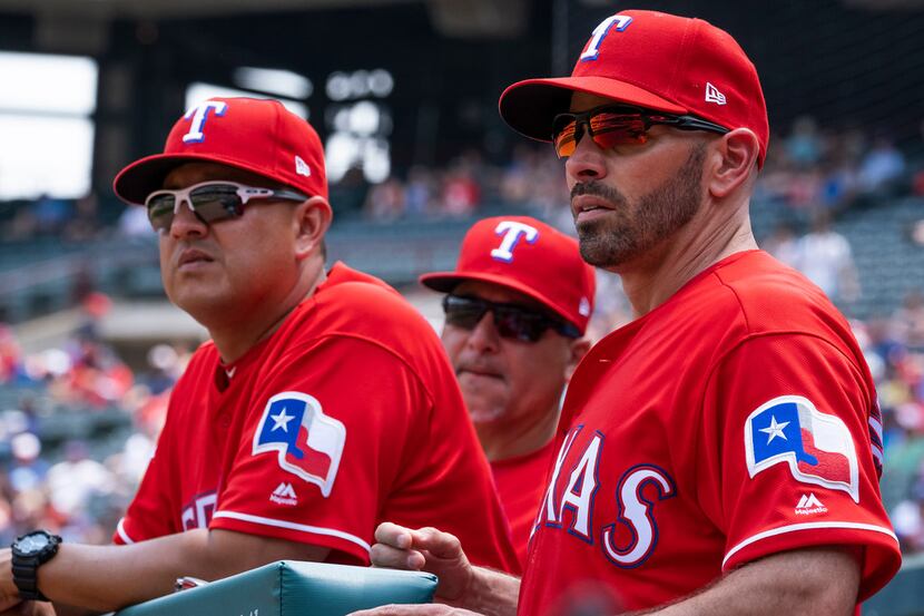 Texas Rangers manager Chris Woodward looks on with pitching coach Julio Rangel (left) and...