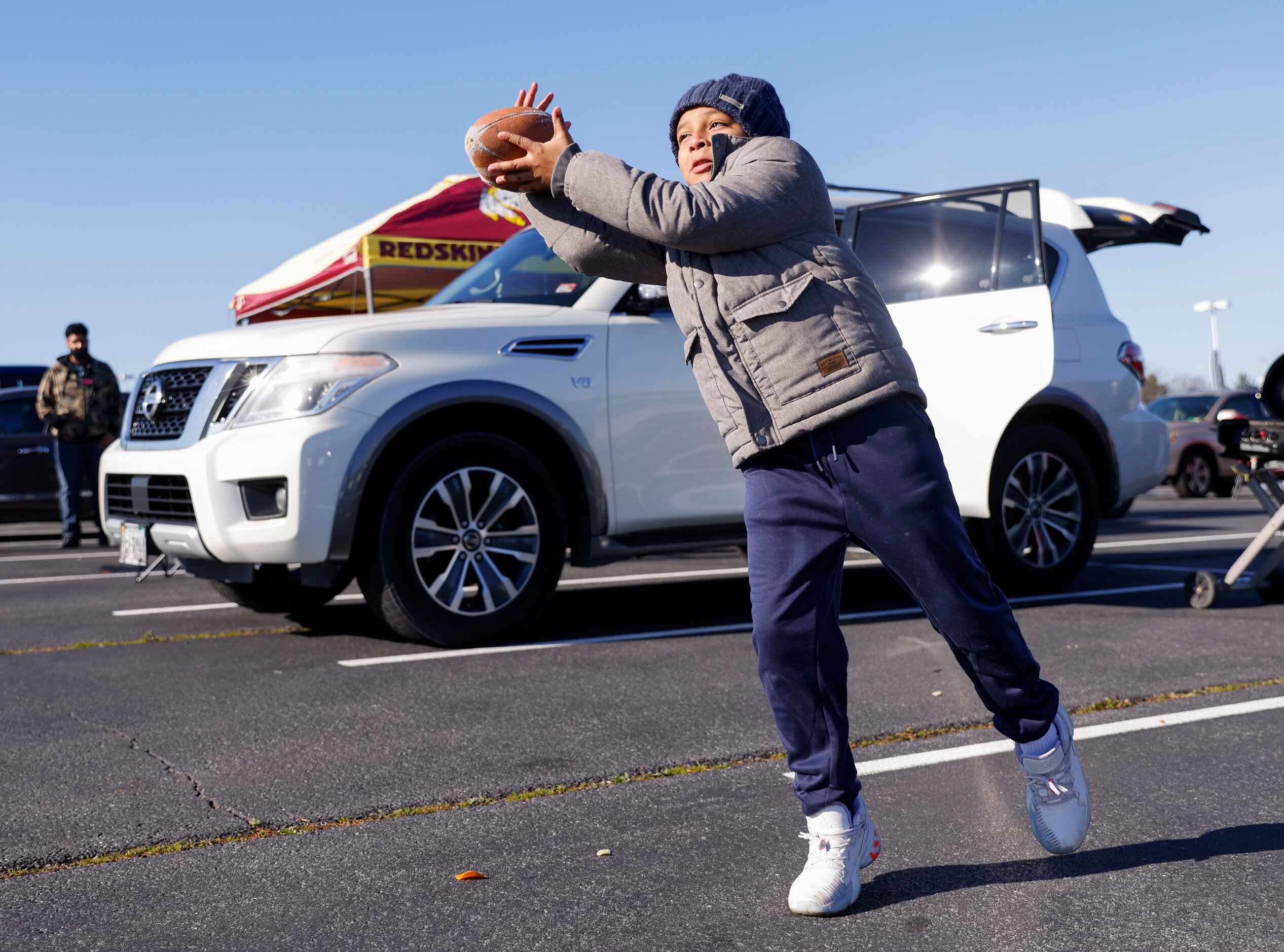 Dallas Cowboys fan Adrian Chavez, 9, of Fairfax, VA plays catch before the start of an NFL...