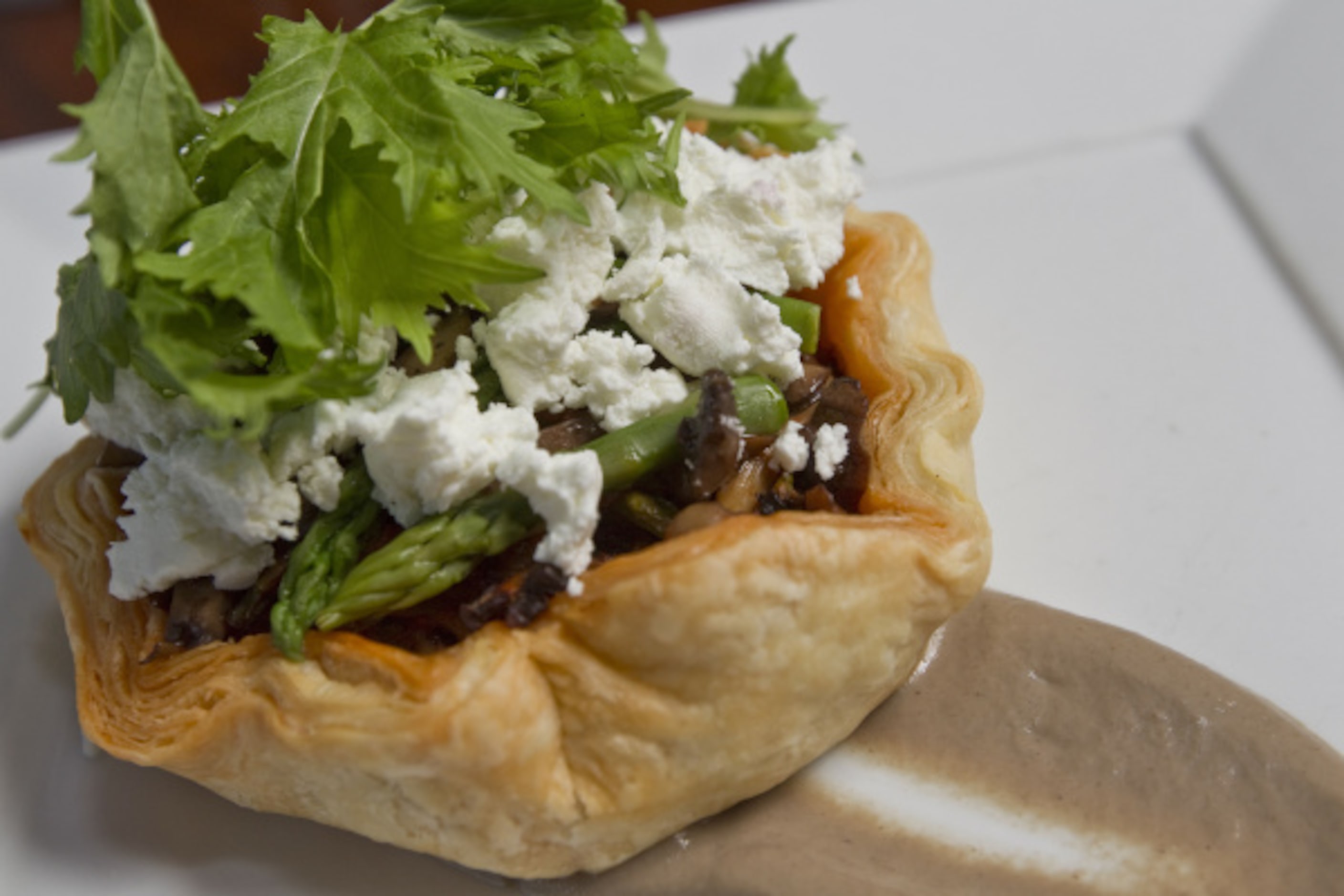 A rustic free-form tart filled with mushrooms and asparagus at Bolsa in Dallas.