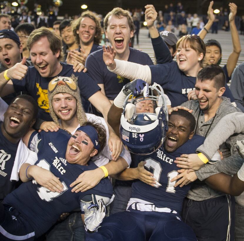 Rice safety Paul Porras (24) and linebacker Broderick Jackson (31) celebrate with fans after...