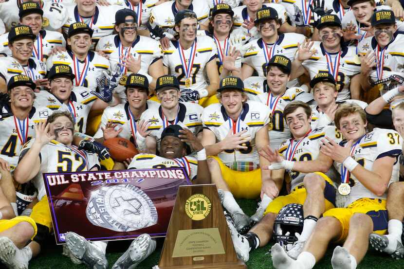 Highland Park football team poses with the trophy after defeating Manvel in the UIL Class 5A...