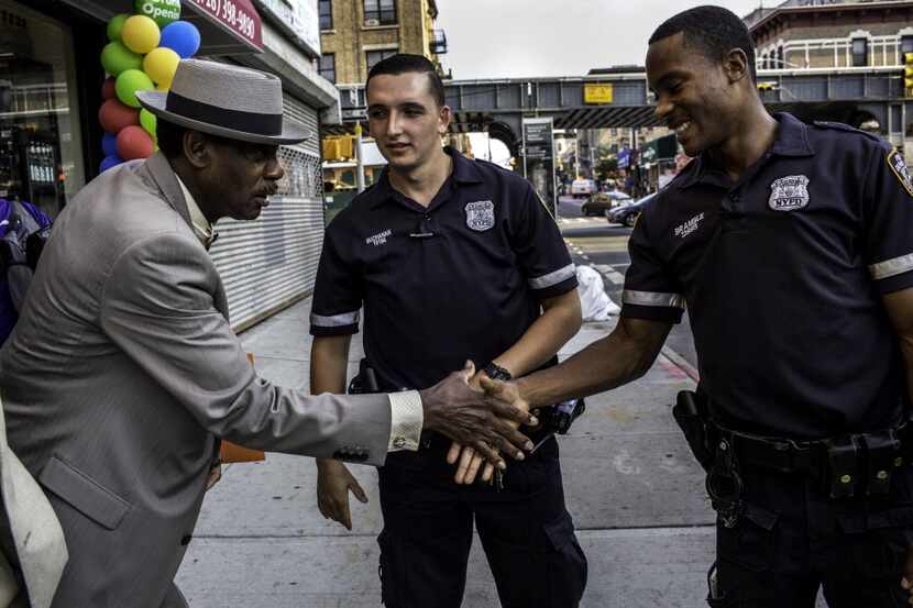 Police officers John Buchanan as Robert Bramble greet a resident in Brooklyn's...