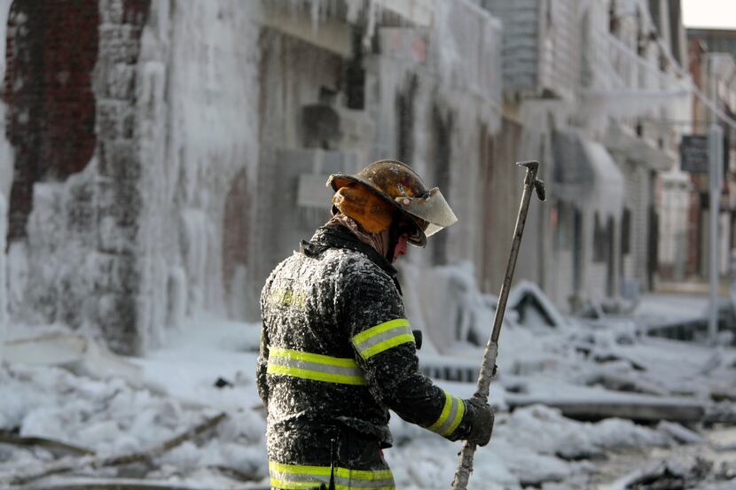 A Philadelphia firefighter works the scene of an overnight blaze in west Philadelphia,...