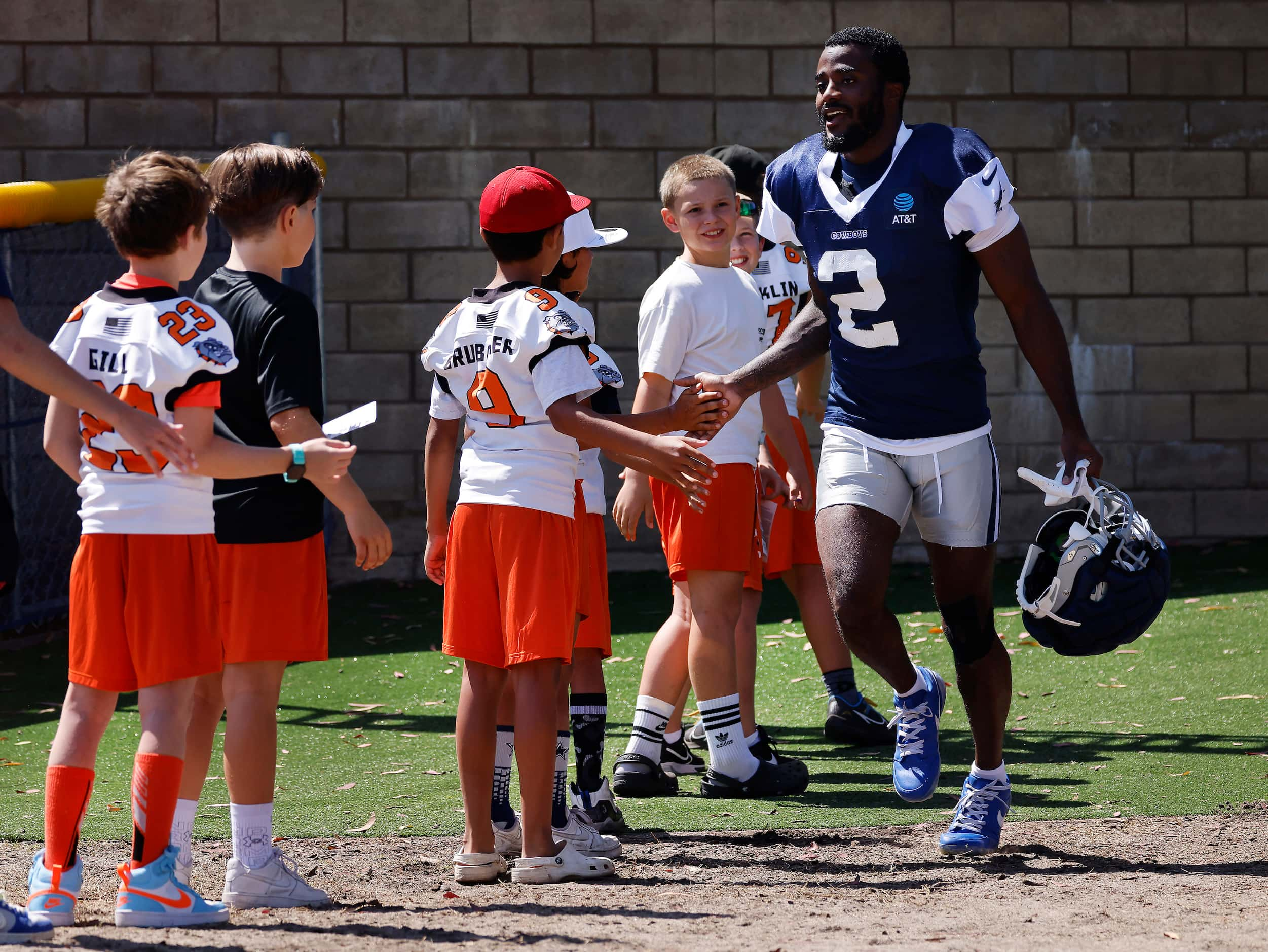 Dallas Cowboys cornerback Jourdan Lewis (2) slaps hands with Simi Valley Bulldogs youth...