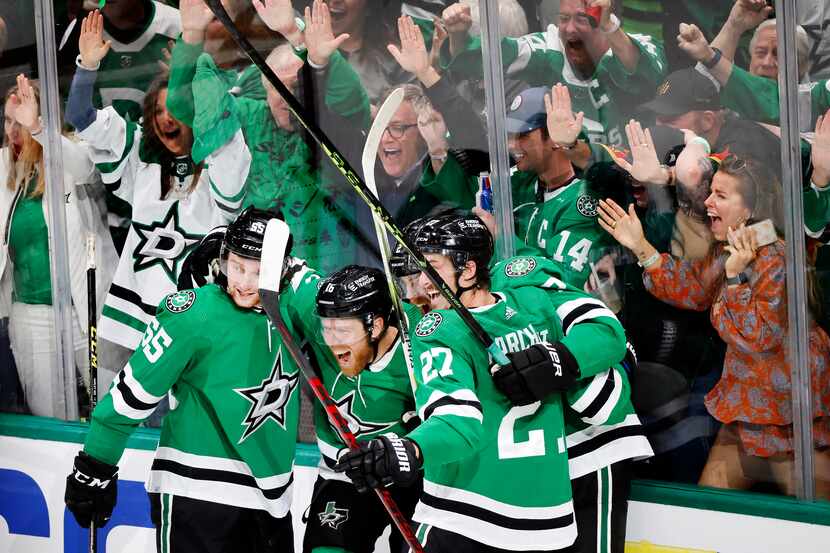 Dallas Stars center Joe Pavelski (16, center) is congratulated by teammates after his fourth...