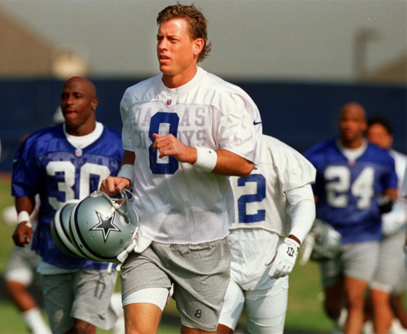  Dallas Cowboys Troy Aikman, center, and Buster Owens, left, run laps with teammates during...