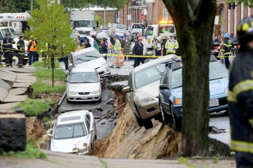 
Cars were perched on the edge of a sinkhole Wednesday in the Charles Village neighborhood...
