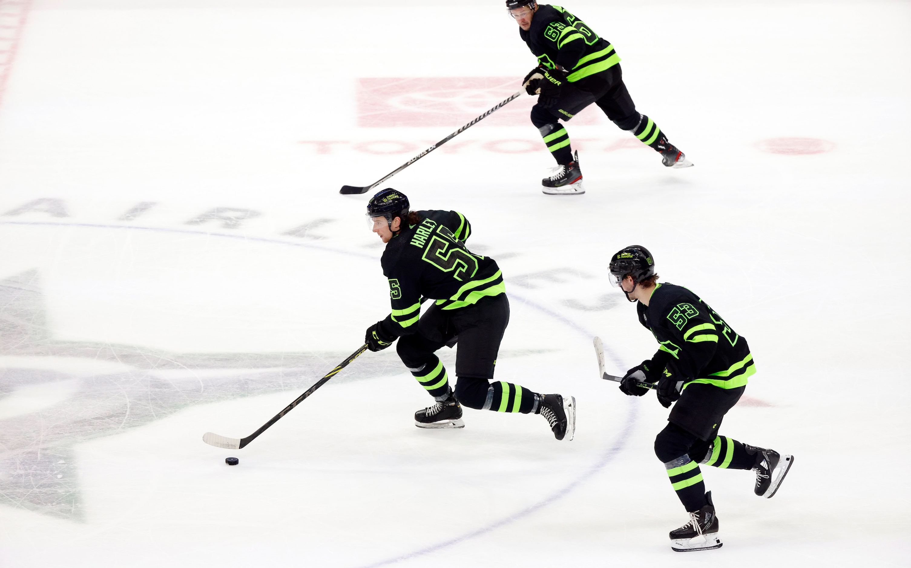 Dallas Stars defenseman Thomas Harley (55) brings the puck up ice with right wing Evgenii...