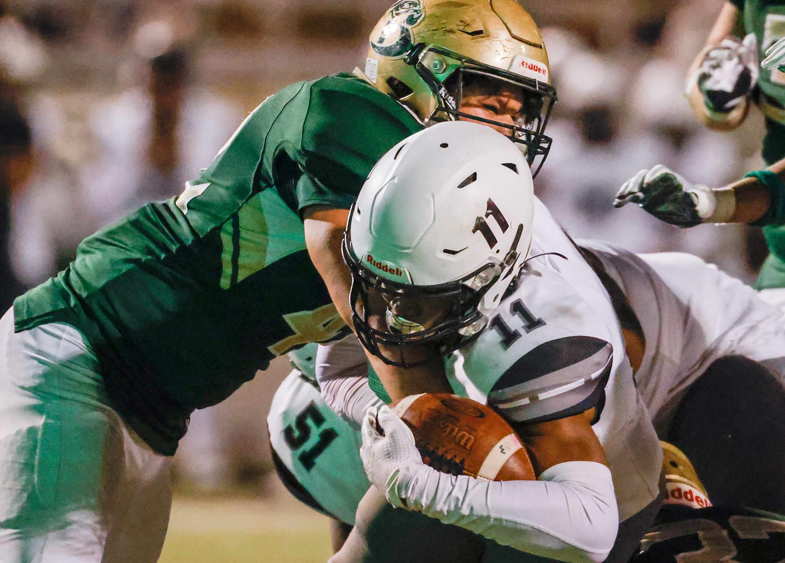 Mansfield Timberview running back Jaylon Woods (11) is tacked by Birdville defense in the...