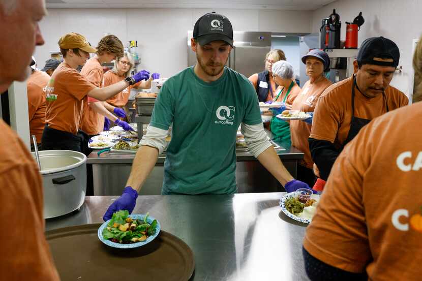 Guest services associate Zane Wittrock loads plates of food onto trays during an annual...