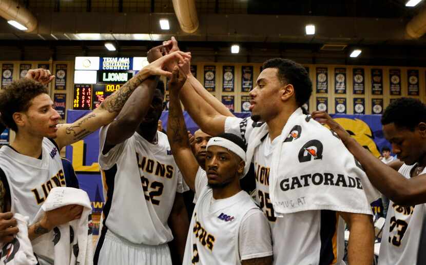 Darrell Williams and his teammates put their hands together at the end of a timeout during a...