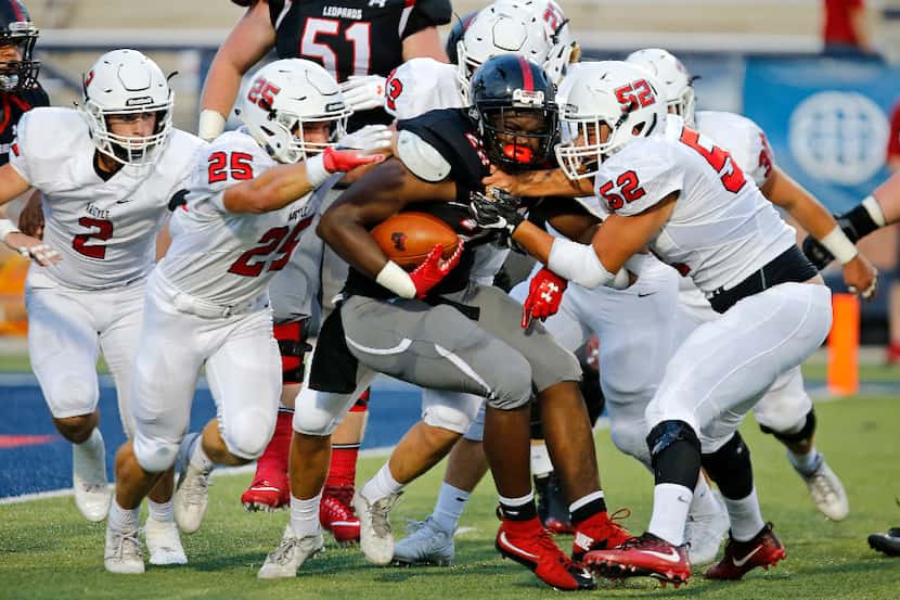 Lovejoy running back Jahi Rainey (28) is met by a host of defenders led by Argyle linebacker...