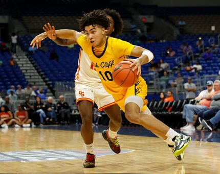 Faith Family's Isaac Williams (10) drives by Stafford's Christian Chambers (13) in the first...