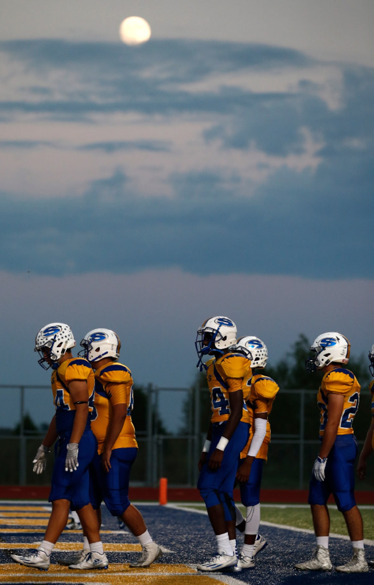 Sunnyvale players walk towards the locker room under the light of the moon before their high...