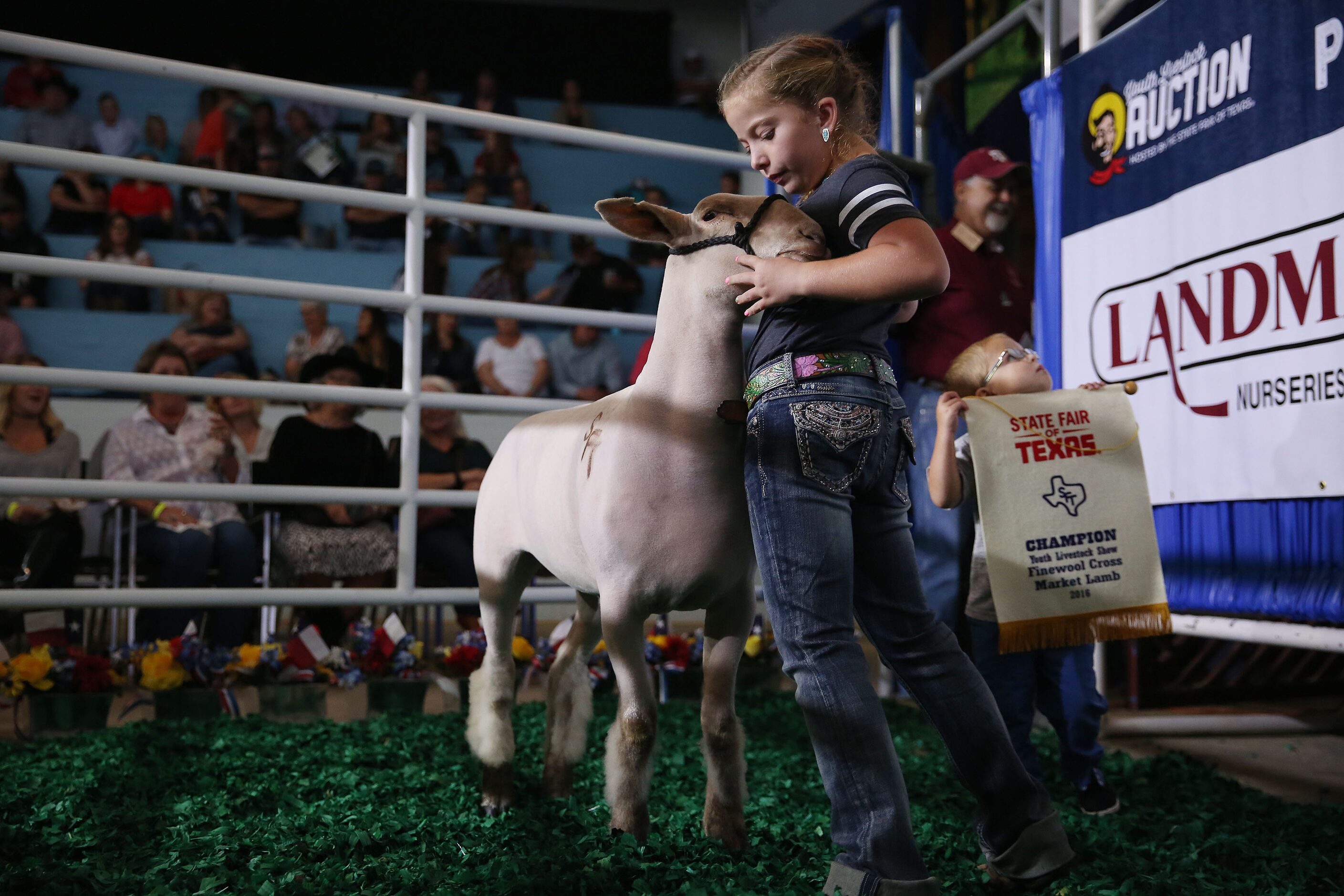 Ella Rea, 10, walks in with her champion lamb and her brother Nixon Rea (right), 2, of San...