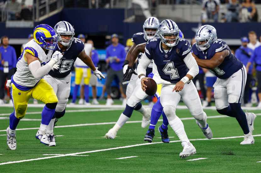 Dallas Cowboys quarterback Dak Prescott (4) looks to pass he scrambles during the first half...