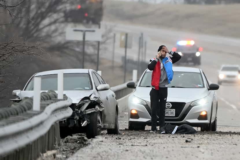 A man reacts after a car accident along US 380 on the Lake Lavon bridge, Wednesday, Feb. 23,...